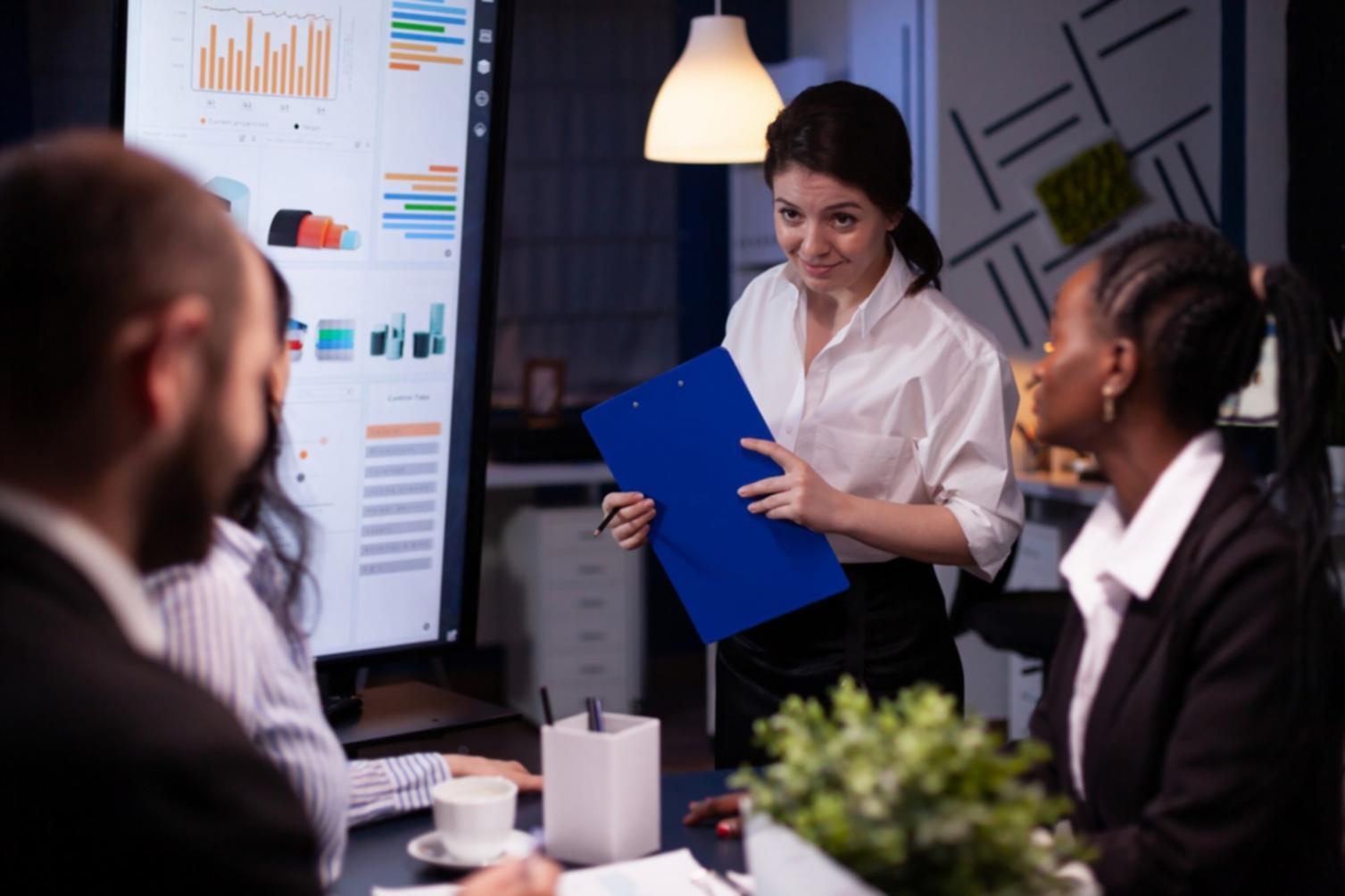 Instructor reviewing financial analysis materials with detailed business reports